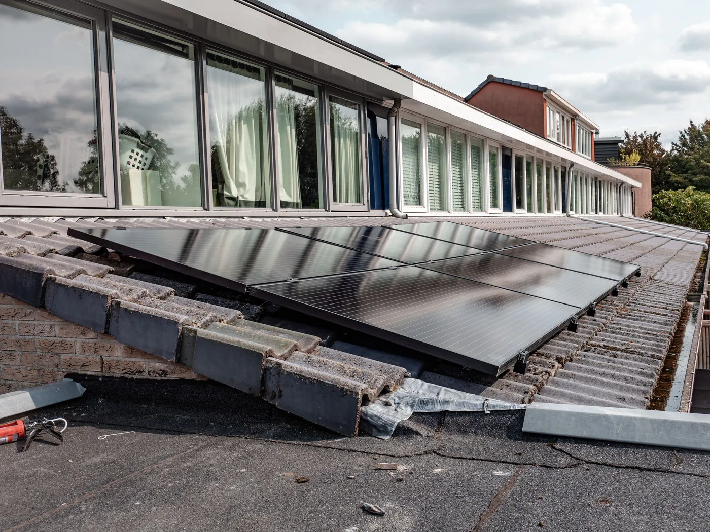 Solar panels being mounted above a tiled roof